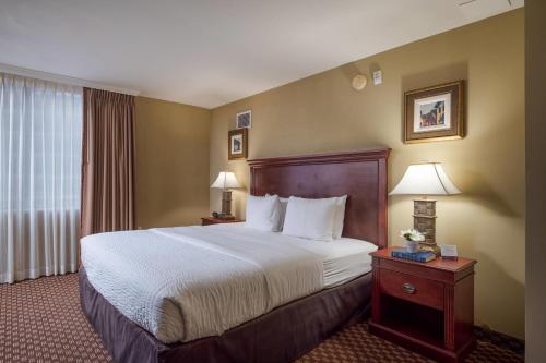a hotel room with a large bed and a window at Clarion Collection Hotel Arlington Court Suites in Arlington
