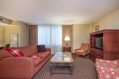 a living room with a couch and a tv at Clarion Collection Hotel Arlington Court Suites in Arlington