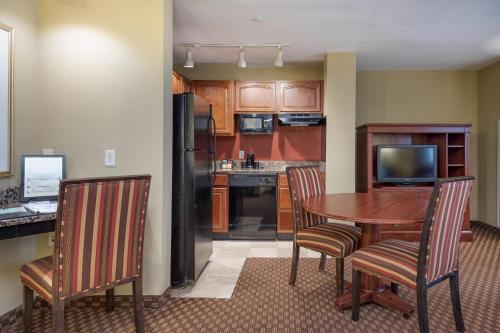a kitchen with a table and chairs and a kitchen with a refrigerator at Clarion Collection Hotel Arlington Court Suites in Arlington