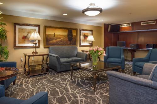 a waiting room with blue chairs and a table at Clarion Collection Hotel Arlington Court Suites in Arlington