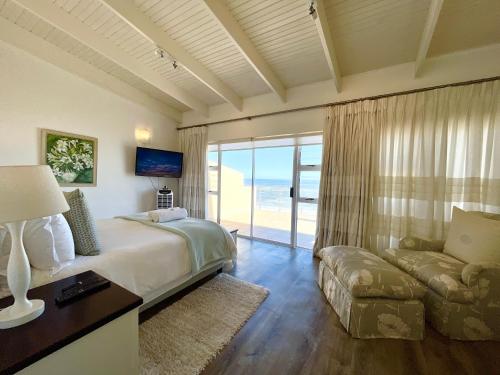 ein Schlafzimmer mit einem Bett und einer Couch und einem Fernseher in der Unterkunft Waterfront Seafront cottage C3 in Swakopmund