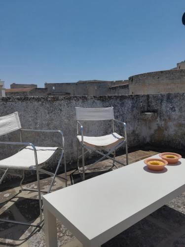 a table and two chairs and a white table and chairs at Vista Castello - Otranto in Otranto