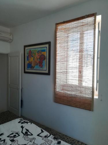 a bedroom with a window and a picture on the wall at Vista Castello - Otranto in Otranto