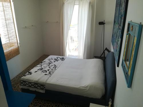 a small bed in a room with a window at Vista Castello - Otranto in Otranto