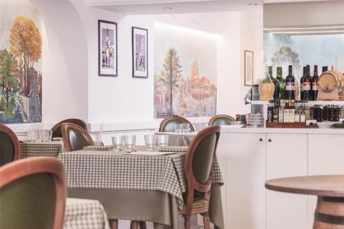 a restaurant with tables and chairs and wine bottles at Radisson Blu GHR Rome in Rome
