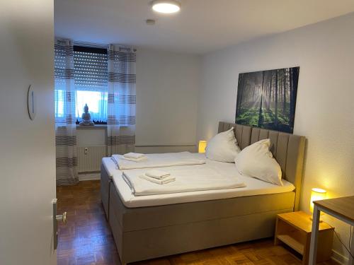 a bedroom with a bed with white sheets and pillows at Colleen Apartments Wesertal in Porta Westfalica