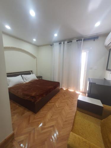 a bedroom with a bed and a wooden floor at زافيرو شارع فؤاد in Alexandria