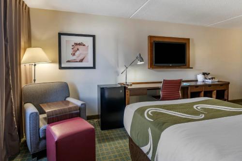 a hotel room with a bed and a desk and a chair at Quality Inn Lexington -Horse Park in Lexington