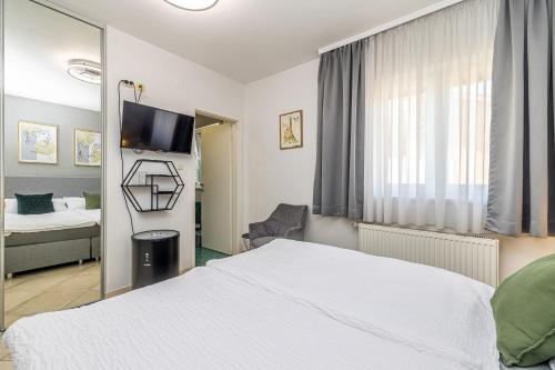 a bedroom with a white bed and a mirror at Bellona in Malinska