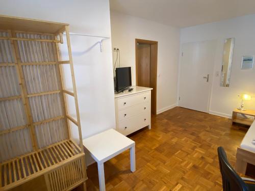 a living room with a white chair and a shelf at Colleen Apartments Wesertal in Porta Westfalica