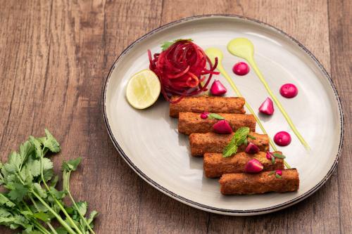 a plate with fish sticks and vegetables on a table at Holiday Inn Gurgaon NH8 by IHG in Gurgaon
