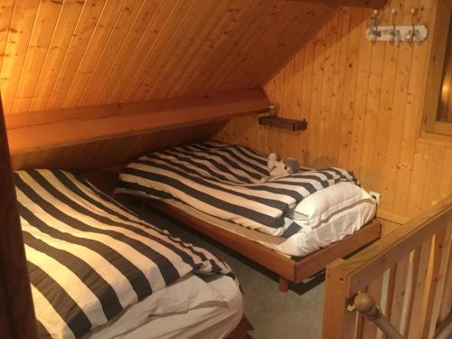 deux lits dans une chambre aux murs en bois dans l'établissement Cabourg California, à Cabourg