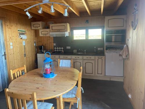 une cuisine avec une table en bois avec une lanterne bleue dessus dans l'établissement Cabourg California, à Cabourg