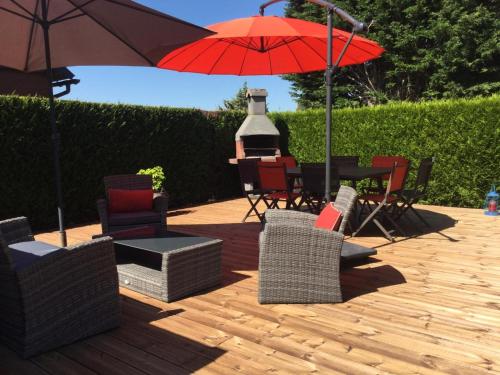 un patio avec des chaises et une table avec un parasol dans l'établissement Cabourg California, à Cabourg