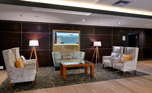 a lobby with chairs and a table and a mirror at Fountains Hotel in Cape Town