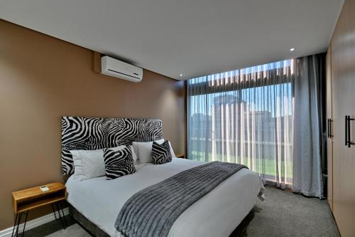 a bedroom with a large bed and a large window at Fountains Hotel in Cape Town