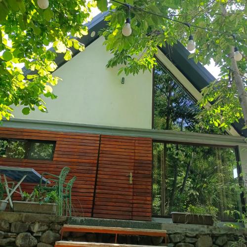 a house with a large window and a stone wall at Woodland Paradise in Gabala