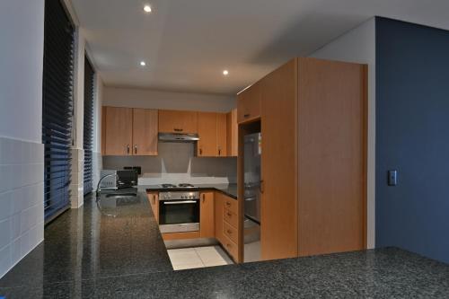 a kitchen with wooden cabinets and a stove at Fountains Hotel in Cape Town