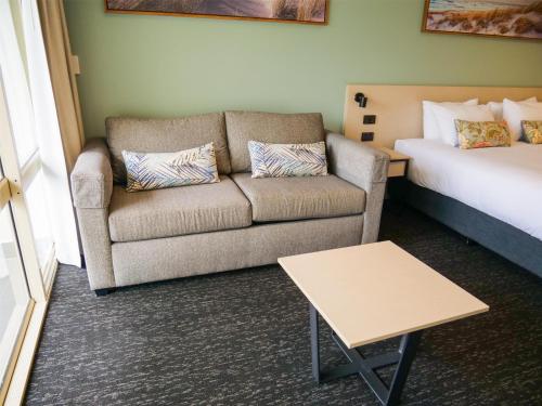 a living room with a couch and a bed at Nightcap at Hinterland Hotel Nerang in Gold Coast