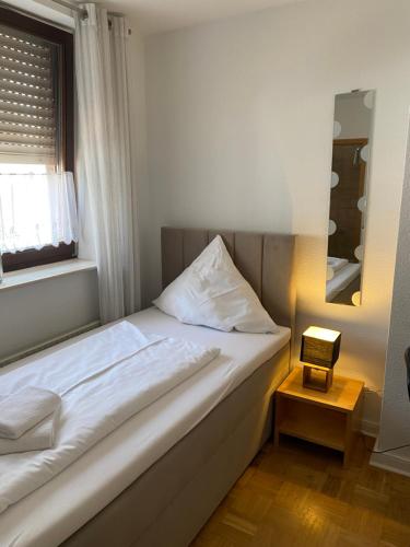 a bedroom with a bed with a window and a night stand at Colleen Apartments Wesertal in Porta Westfalica