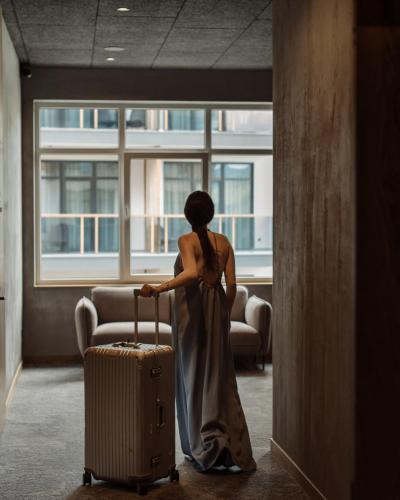 a woman in a dress with a suitcase at Apartel Skhidnytsya in Skhidnitsa