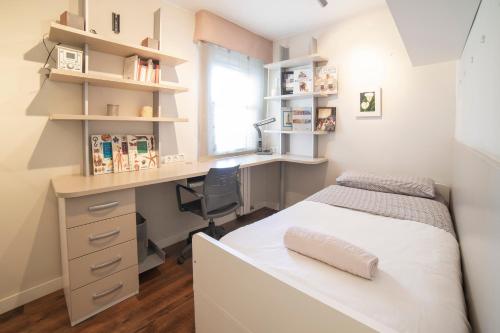 a bedroom with a bed and a desk and a window at La Elegancia del Centro by Alogest in Zaragoza