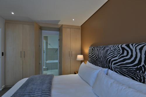 a bedroom with a bed with a zebra print pillow at Fountains Hotel in Cape Town