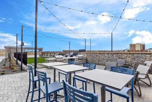 a patio with tables and chairs and a brick wall at Everhome Suites Cheyenne in Cheyenne
