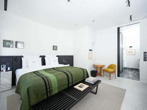 アテネにあるAthens Capital Suites-MGallery Collectionのベッドルーム(大型ベッド1台、テーブル付)