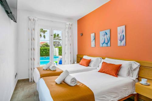 Villa Betty في كالا إن بلانيس: سريرين في غرفة بجدران برتقالية