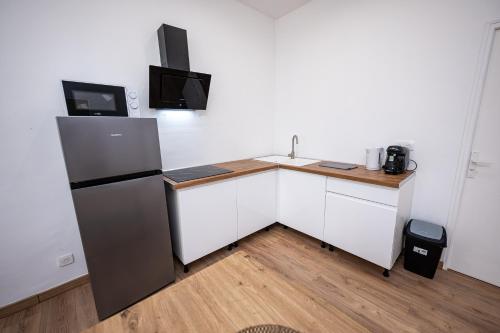  La cuisine est équipée de placards blancs et d'un réfrigérateur. dans l'établissement Vincent à deux pas du Vieux Port, à Marseille