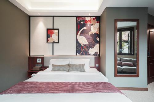 a bedroom with a large white bed and a window at STORIES Joo Chiat, a Hotel by Cove - Paya Lebar, Singapore - NEWLY RENOVATED in Singapore