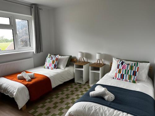 a room with two beds and a window at Entire home in Gronant, United Kingdom in Talacre