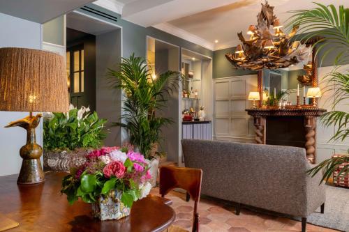 a living room with a table with flowers on it at Hôtel Aubépine in Paris