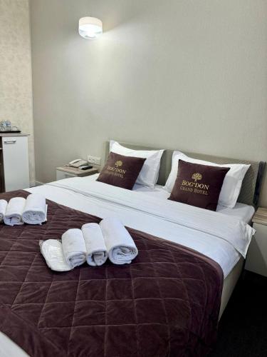 a large bed with white towels and pillows on it at BOG'DON GRAND Hotel in Tashkent