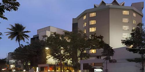 a tall building with a tree in front of it at Regenta Place Bangalore, Cunningham Road in Bengaluru