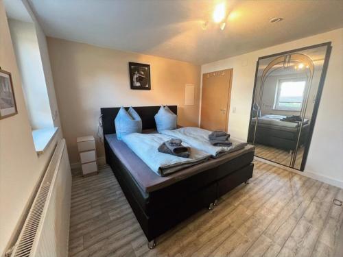 a bedroom with a bed with a large mirror at Ferienwohnung Rhön mit Terrasse im Grünen in Burkardroth