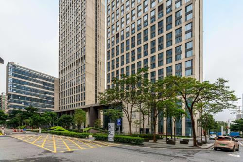 a tall building with a parking lot in front of it at Bulgari Serviced Residences Guangzhou in Guangzhou