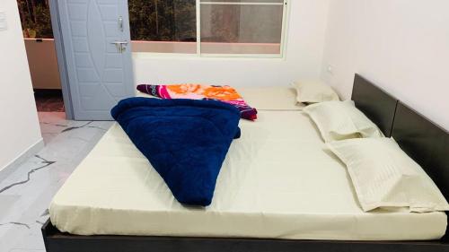 a large white bed with a blue blanket on it at Anwaya Homestay Chikmagalur in Avathi