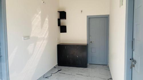 a hallway with a blue door and a white wall at Anwaya Homestay Chikmagalur in Avathi