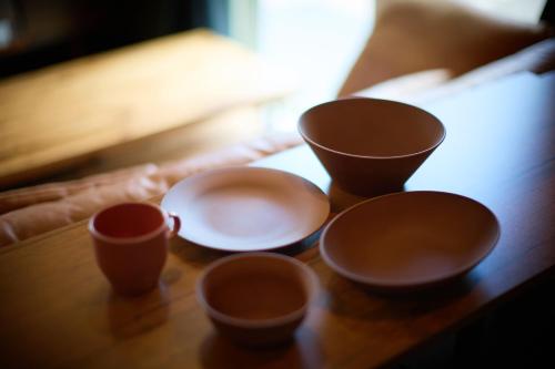 a group of cups sitting on a wooden table at CODE ROOMS OKINAWA 今帰仁の貸切宿 BBQと自然を満喫 美ら海水族館 ジャングリア沖縄まで車で20分 最大7名ok in Nakijin