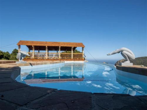 a swimming pool with a gazebo in the background at Castle On The Heads in Knysna