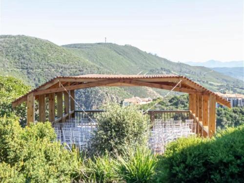 a wooden pavilion with mountains in the background at Castle On The Heads in Knysna