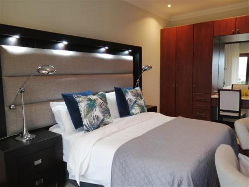 a bedroom with a large white bed and a desk at Castle On The Heads in Knysna