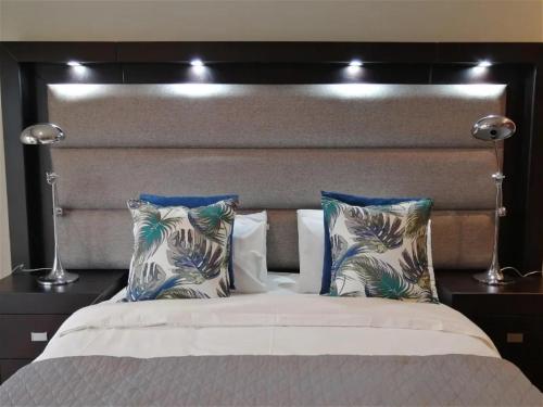 a bedroom with a large bed with blue and white pillows at Castle On The Heads in Knysna