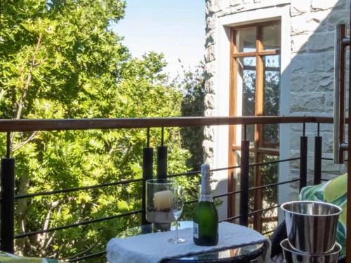 a table on a balcony with a bottle of wine at Castle On The Heads in Knysna