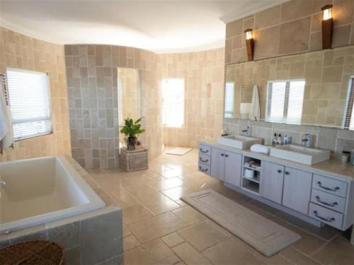 a large bathroom with two sinks and a tub at Castle On The Heads in Knysna
