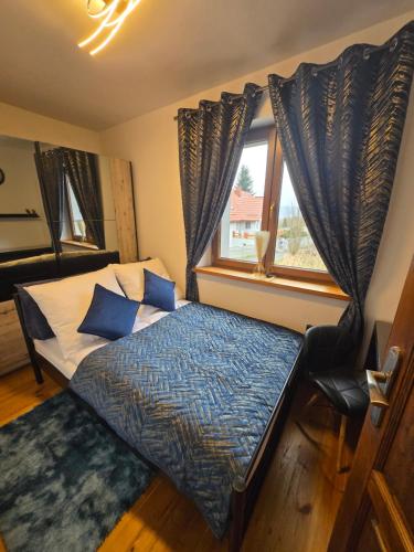 een slaapkamer met een bed en een raam bij Gniazdko Czarodzieja in Jedlina-Zdrój