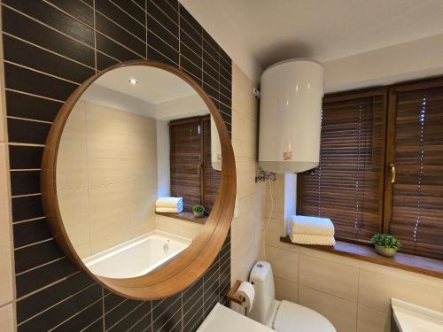 een badkamer met een ronde spiegel en een bad bij Gniazdko Czarodzieja in Jedlina-Zdrój