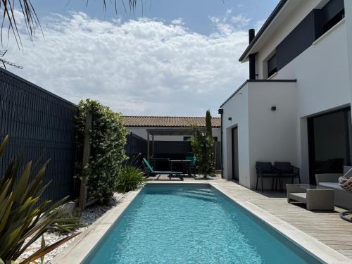 a swimming pool in the backyard of a house at Villa avec piscine proche plages in Vaux-sur-Mer